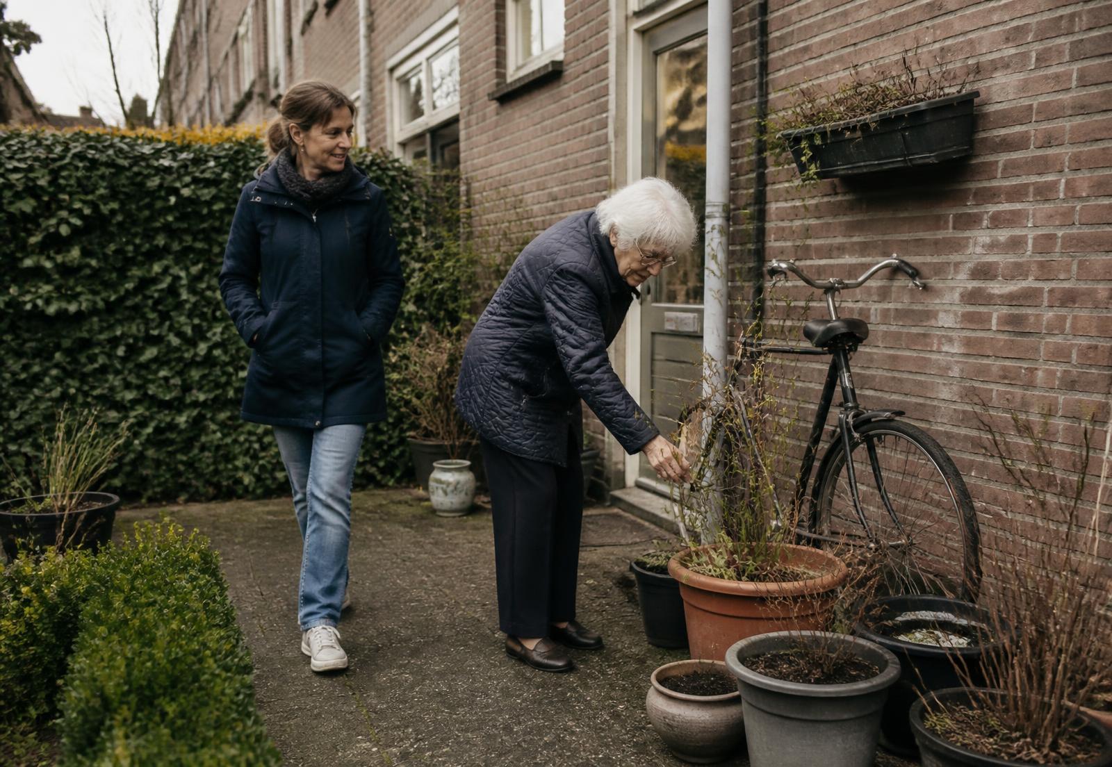 Bewoner verzorgt samen met een naaste de planten in de tuin van een woonzorglocatie